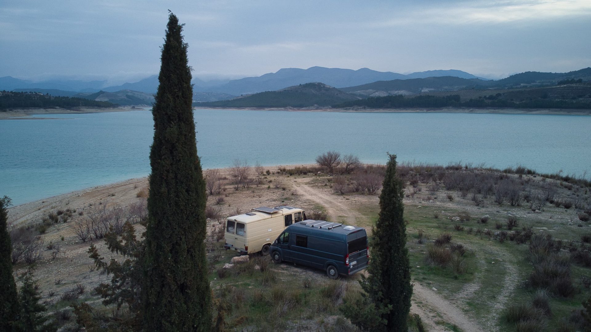 Our Vanderlust Zwei Camper Vans vor einem Stausee