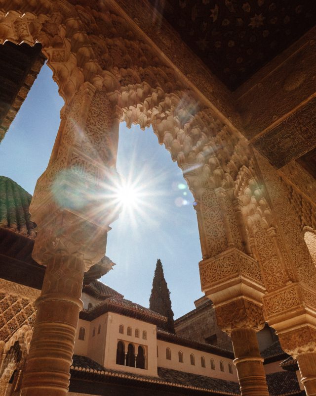Sonne hinter einer Säule der Nasriden Paläste in der Alhambra